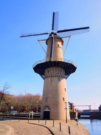 Low angle view of traditional windmill against clear sky