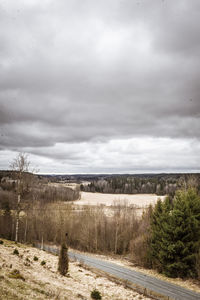 Scenic view of field against cloudy sky