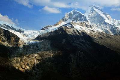 Low angle view of snowcapped mountains against sky 