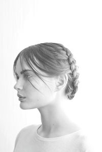 Close-up portrait of a young woman against white background