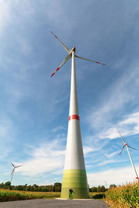 Low angle view of windmill on field against sky