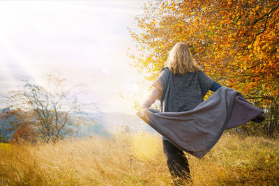 A woman of fourty years in autumn landscape. the blonde woman wears clothes made of wool and boots