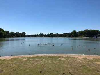 Scenic view of lake against clear blue sky