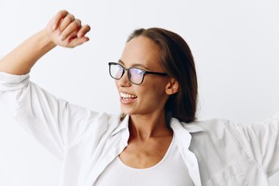 Young woman wearing sunglasses against white background