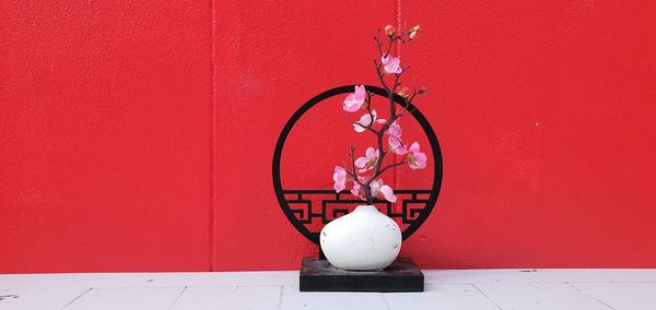 Close-up of clock against red wall