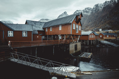 Buildings by river against sky