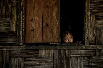 Close-up of boy peeking through door