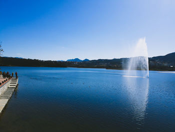 Scenic view of lake against clear blue sky