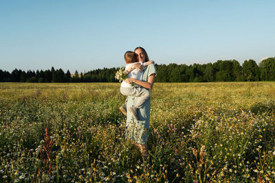 Rear view of woman standing on field