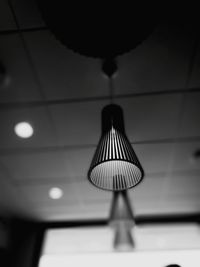 Close-up of illuminated lighting equipment hanging from ceiling