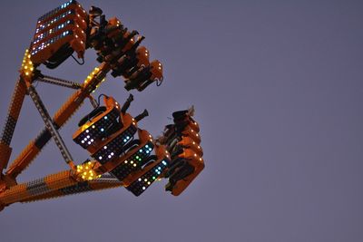 Low angle view of illuminated carousel against clear sky