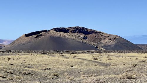 Scenic view of desert against clear blue sky