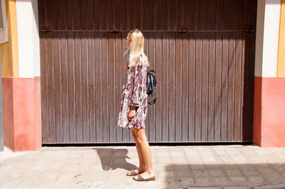 Woman standing against built structure