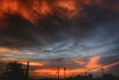 Silhouette trees against orange sky