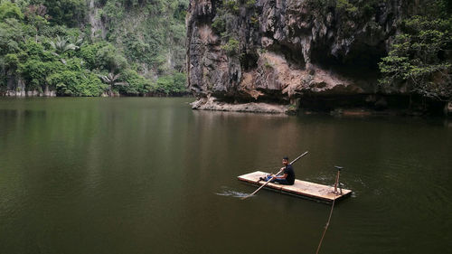 Man on wooden raft in lake