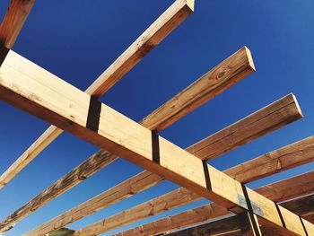 Low angle view of wood structure against blue sky