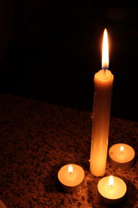 Close-up of lit candle in dark room