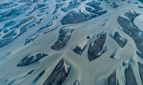 High angle view of snow covered land by sea