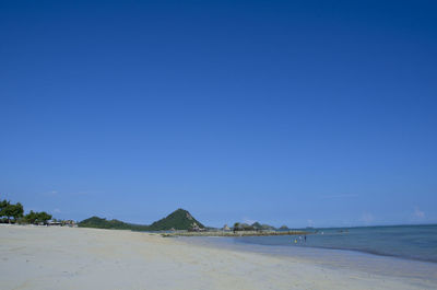 Scenic view of beach against clear blue sky