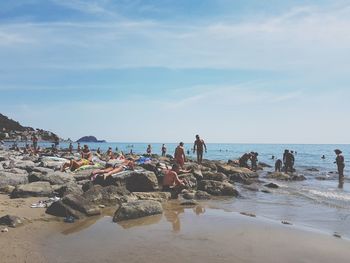 People at beach against sky