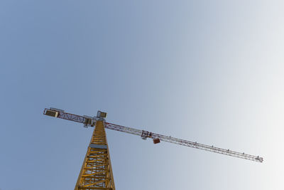Low angle view of crane against clear sky