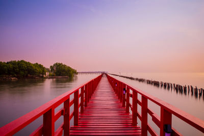 Pier over sea against sky during sunset