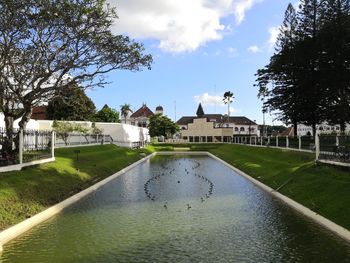 Canal by buildings against sky