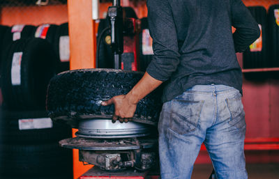 Rear view of mechanic working in workshop