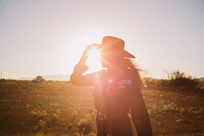 Woman in cowboy hat with sun flare