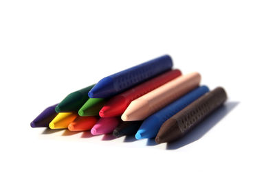 Close-up of colored pencils over white background