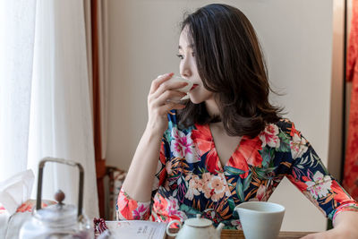 Woman holding drink at home