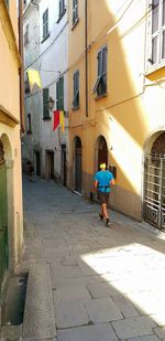 Man walking on street amidst buildings in city