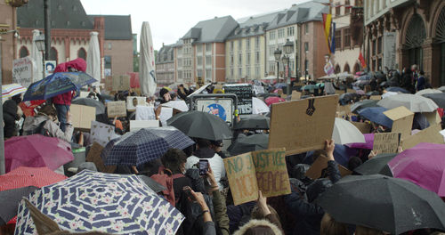 People on street against buildings in city