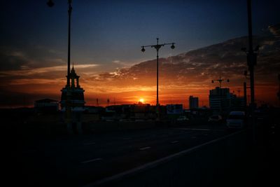 Silhouette city against sky at sunset