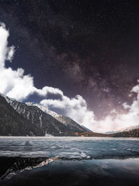 Scenic view of snowcapped mountains against sky at night