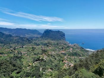 Scenic view of sea and mountains against sky