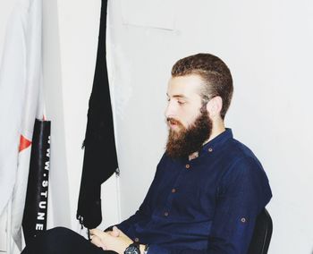 Portrait of man standing against wall