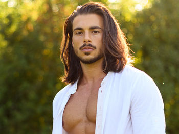Portrait of man standing against plants in park