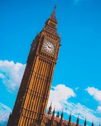 Low angle view of clock tower against cloudy sky