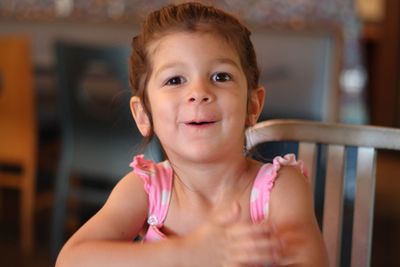 Portrait of girl on chair at home