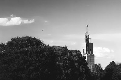 Tower and trees against sky on sunny day