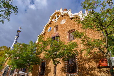 Low angle view of trees and building against sky