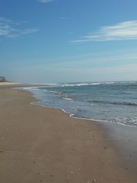 Scenic view of beach against blue sky