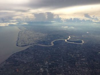 Aerial view of city by sea against sky