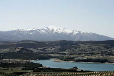 Scenic view of lake by mountains against sky