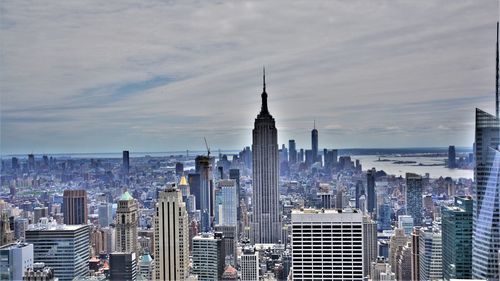 Modern buildings in city against cloudy sky