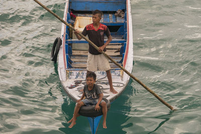 High angle view of men sailing on boat in sea