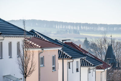 Houses by building against sky during winter
