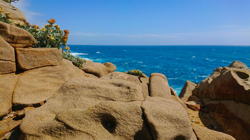 Scenic view of rocks on beach against sky