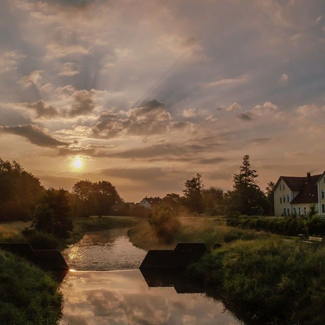 sunset, water, sky, tree, reflection, cloud - sky, tranquil scene, scenics, beauty in nature, building exterior, tranquility, waterfront, built structure, river, architecture, nature, lake, cloud, house, idyllic